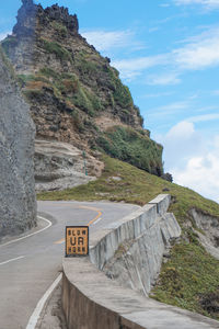 Road leading towards mountain against sky