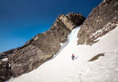 People on snowcapped mountain against sky