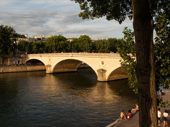 Arch bridge over river against sky