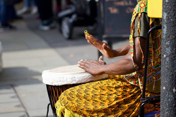 Midsection of man playing drum