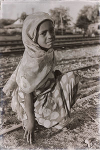 Girl sitting on railroad track