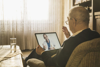 Rear view of man using laptop