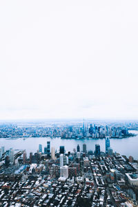 High angle view of buildings by sea against clear sky
