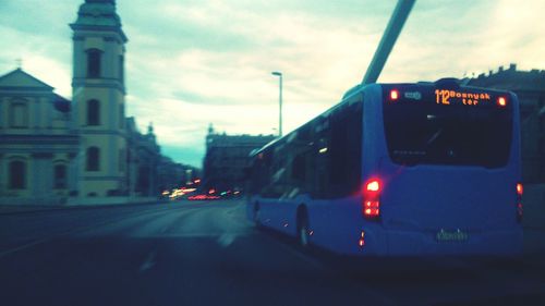 Cars on road against cloudy sky