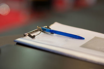 Close-up of pen and file on clipboard at table