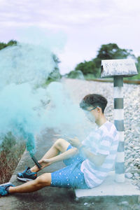 Man sitting in water against sky