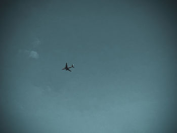 Low angle view of silhouette airplane flying in sky