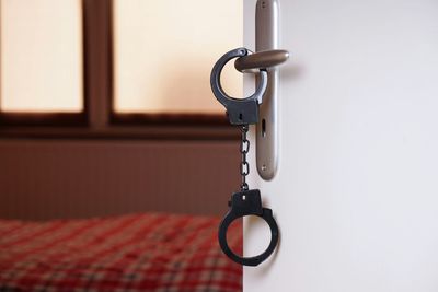 Close-up of handcuffs hanging on door