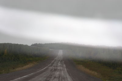 Road amidst trees against sky