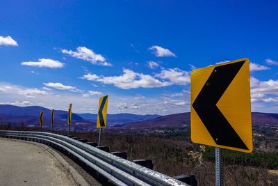 Road sign against sky