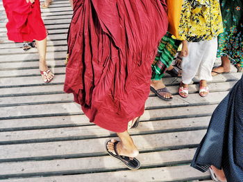 Low section of women walking on wooden footbridge