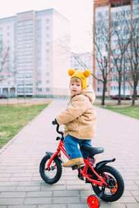 A small child learns to ride a bike for the first time in the city in spring