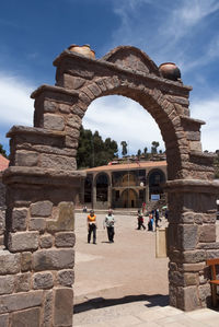 People at historical building against sky