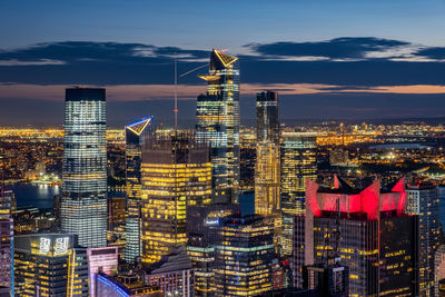 Illuminated buildings in city against sky