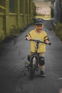 Portrait of cute 2 year old toddler riding a push bike