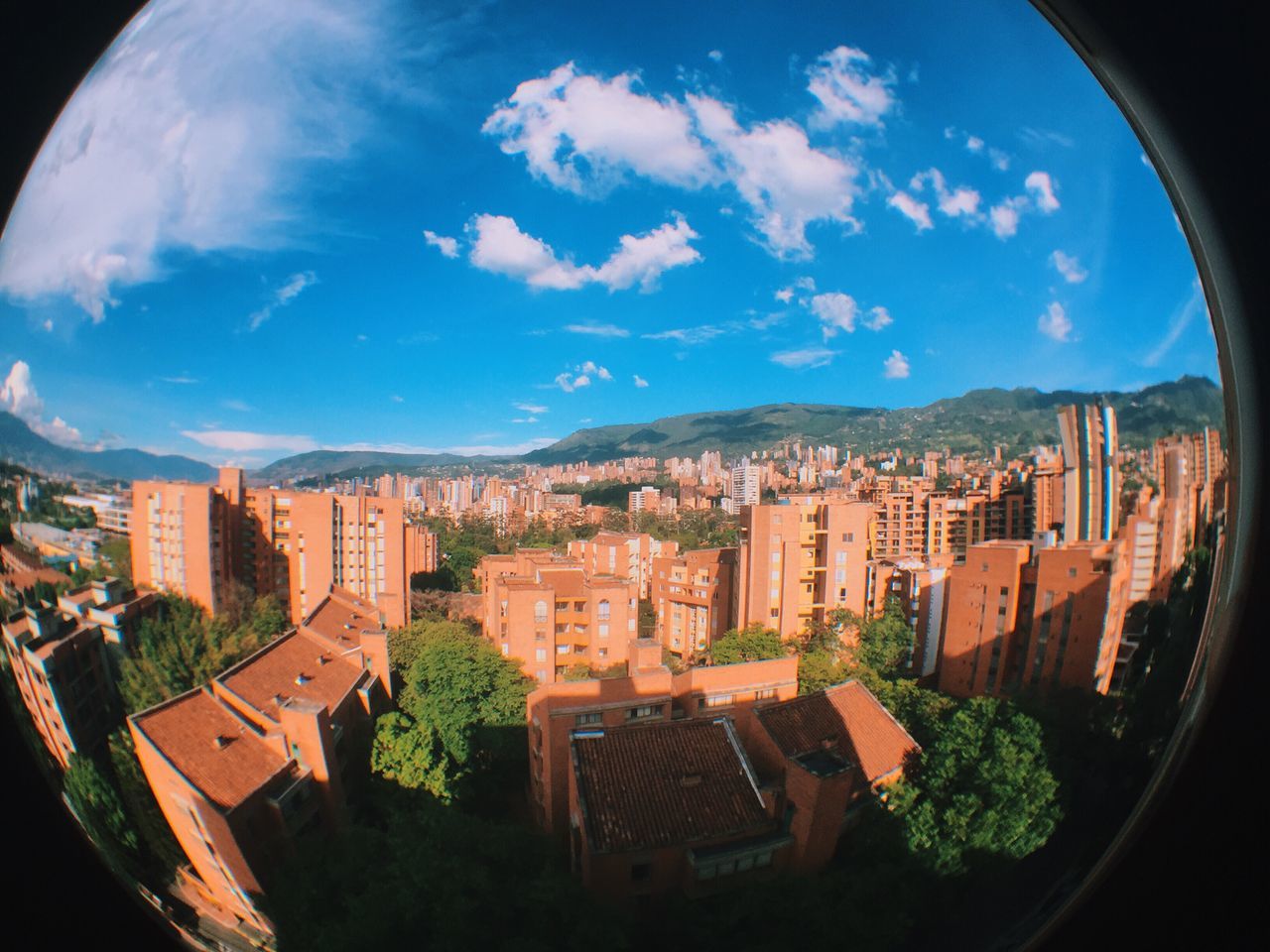 architecture, built structure, building exterior, sky, cityscape, city, blue, residential district, residential structure, cloud - sky, high angle view, cloud, residential building, fish-eye lens, house, town, tree, day, mountain, crowded