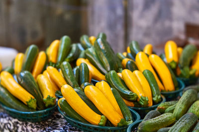 Zucchinis in plastic container at market stall