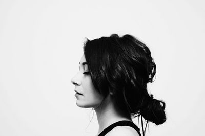 Portrait of young woman against white background