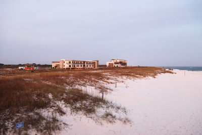 Building by sea against sky during winter