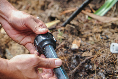 Cropped hands repairing pipe