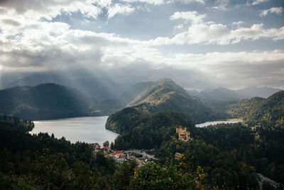 Sun rays shine on hohenschwangau castle from neuschwanstein castle in bavaria, germany.