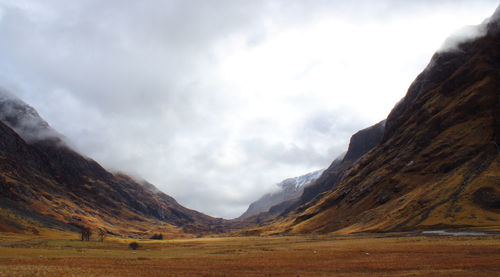 Scenic view of mountains against cloudy sky