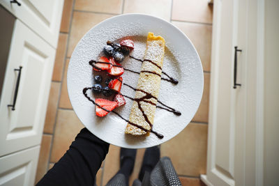 Midsection of person holding dessert in plate