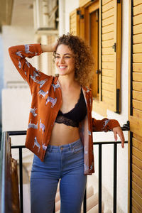 Portrait of young woman with arms crossed standing in city