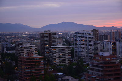 Buildings in city against sky during sunset