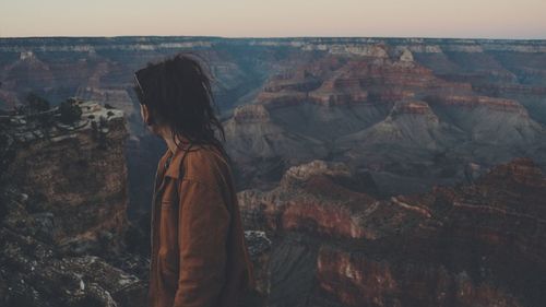 Rear view of person standing on rock formation