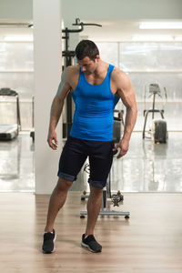 Muscular man wearing vest standing in gym