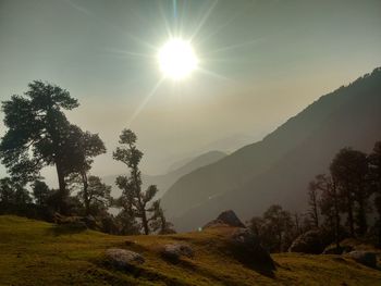 Scenic view of landscape against bright sun