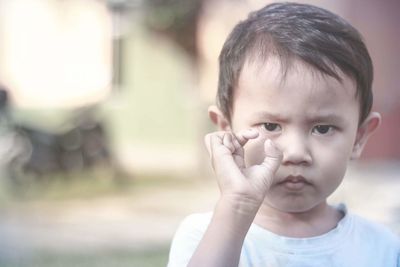 Portrait of cute angry boy gesturing outdoors