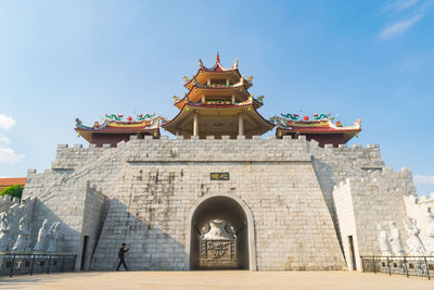 Man walking by temple in city