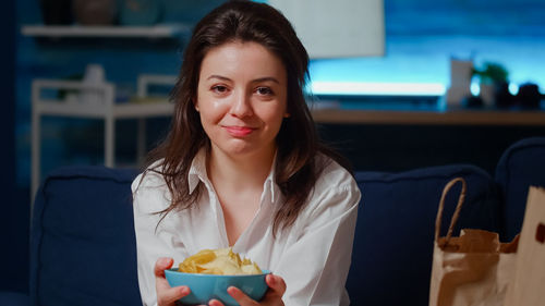 Portrait of woman holding bowl of chips