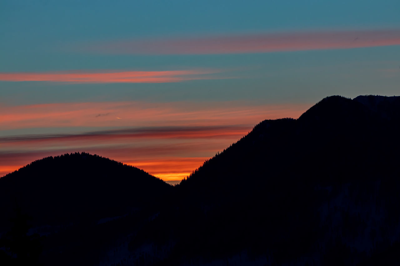 SILHOUETTE MOUNTAINS AGAINST DRAMATIC SKY DURING SUNSET