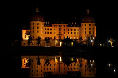 Reflection of illuminated building in water at night