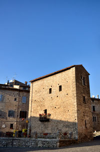 Low angle view of old building against clear blue sky