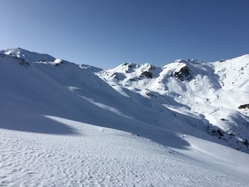 Scenic view of snowcapped mountains against clear blue sky