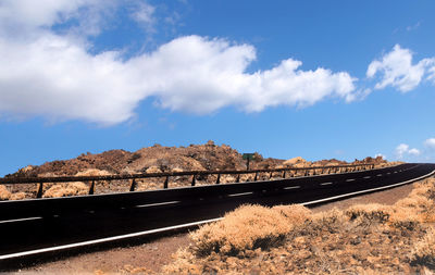 Road leading towards mountain against sky