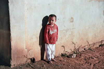 Portrait of smiling boy standing against wall