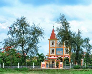 Traditional building by trees against sky