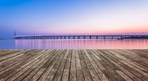 Pier over sea against clear sky during sunset