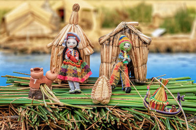 Toys on wicker basket by water in park