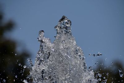 Close-up of frozen water splashing against clear blue sky