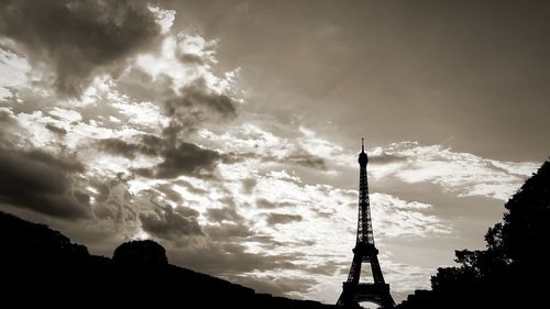 Low angle view of silhouette building against cloudy sky