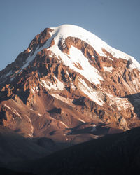 Aerial view of snowcapped mountains against clear sky
