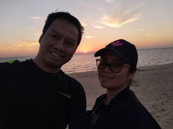 Portrait of smiling man in sea against sky during sunset