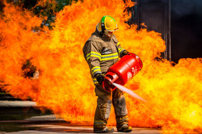 Rescue worker spraying extinguisher on fire