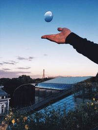 Hand against sky during sunset